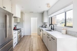 Double galley kitchen with skylight and white cabinets.