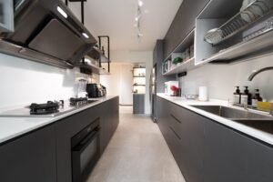 Black and white double galley kitchen with modern lighting.