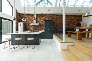 Industrial double galley kitchen with brick wall and metal shelving.