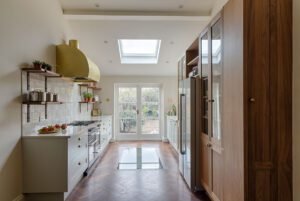 Modern double galley kitchen with white cabinets and quartz countertops.